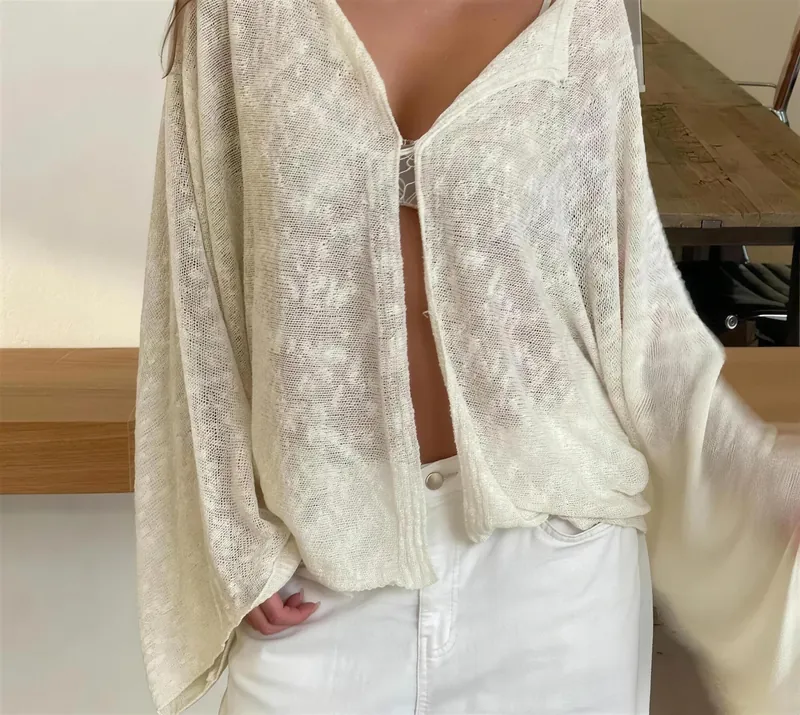 Cream boat-neck cover-up cardigan worn open over white trousers