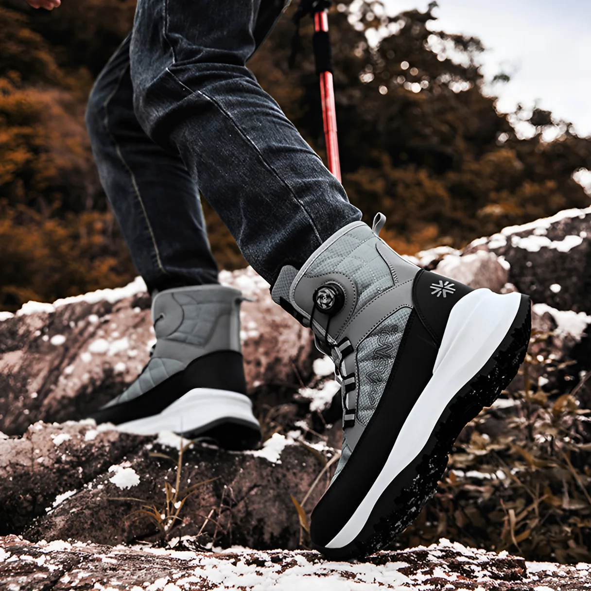 Gray boots mid-stride on a snowy rock