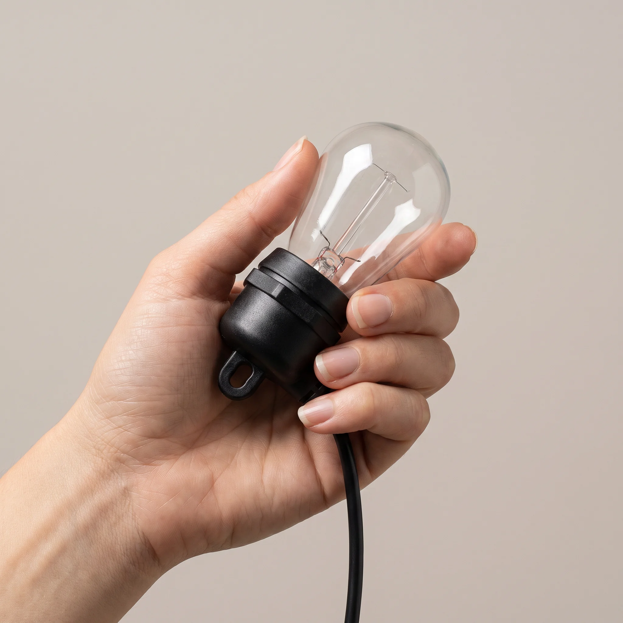 Adult hand holding one bulb and socket to show its real size