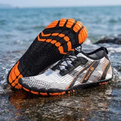 White and orange water shoes on the shoreline