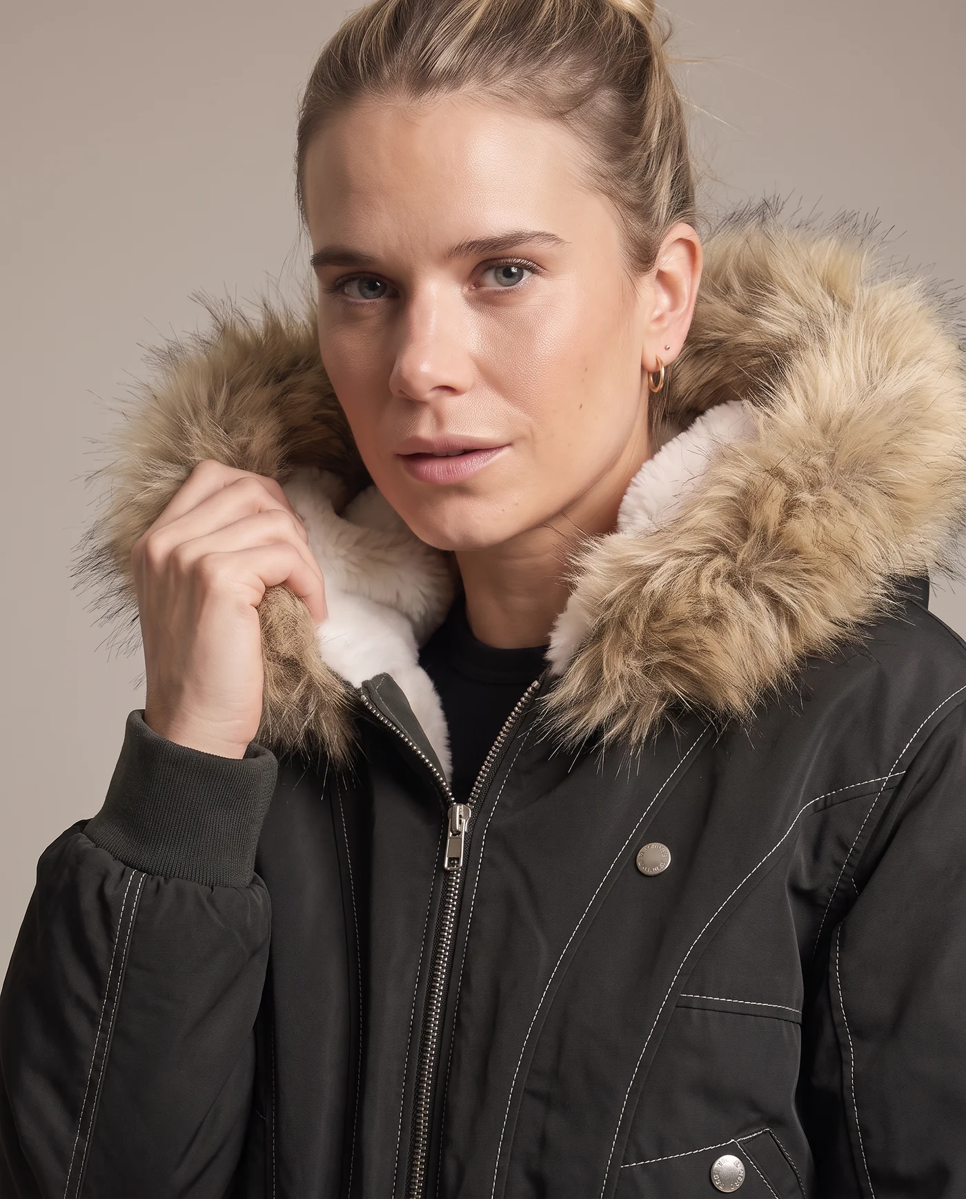 Close shot of the black bomber jacket with the tan faux fur hood trim framing the face