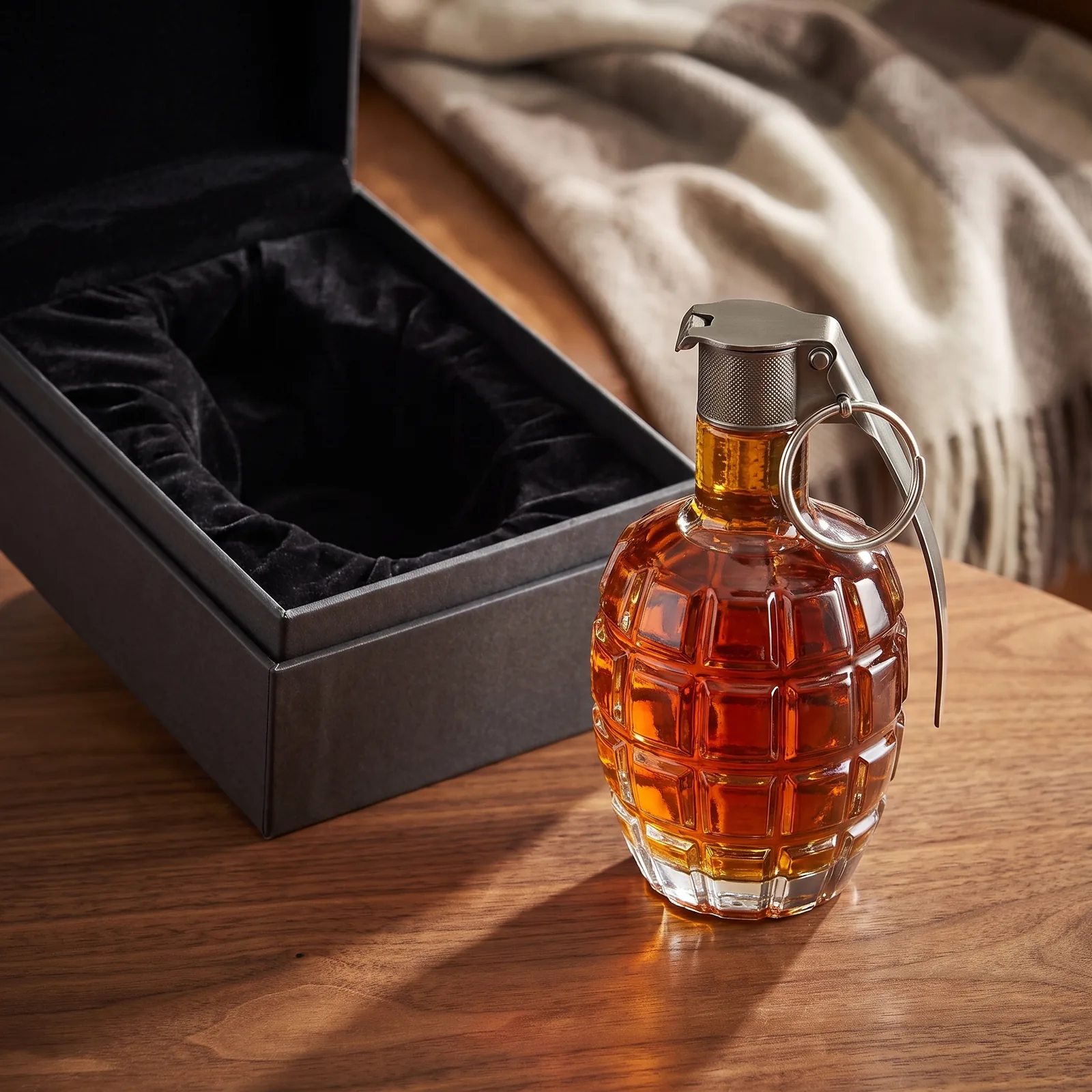 The grenade decanter beside an open lined gift box