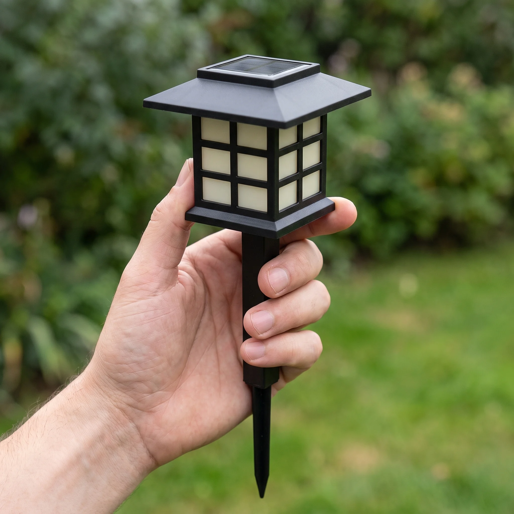 Hand holding a single solar lantern path light to show its size