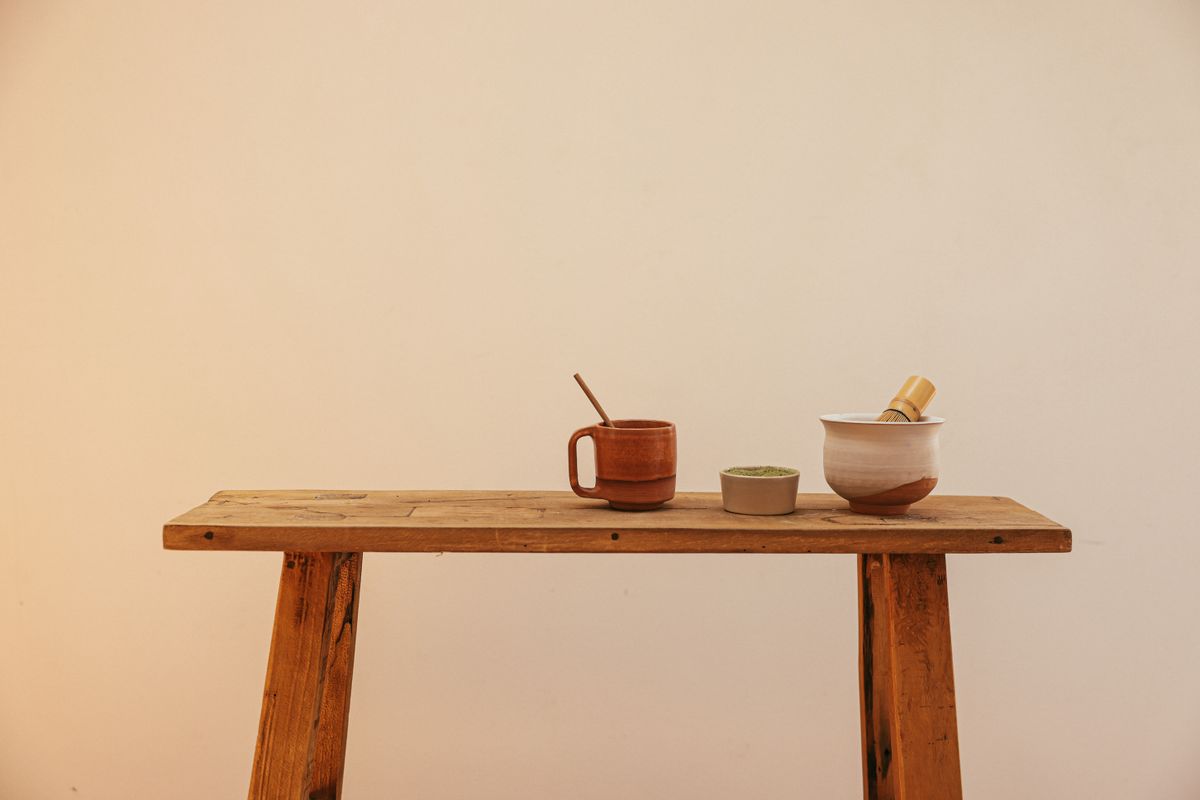 A minimalist display of a rustic tea set on a wooden table, perfect for organic lifestyle aesthetics.
