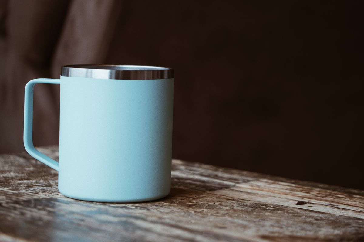 Light blue mug on a rustic wooden table, perfect for coffee or tea lovers.