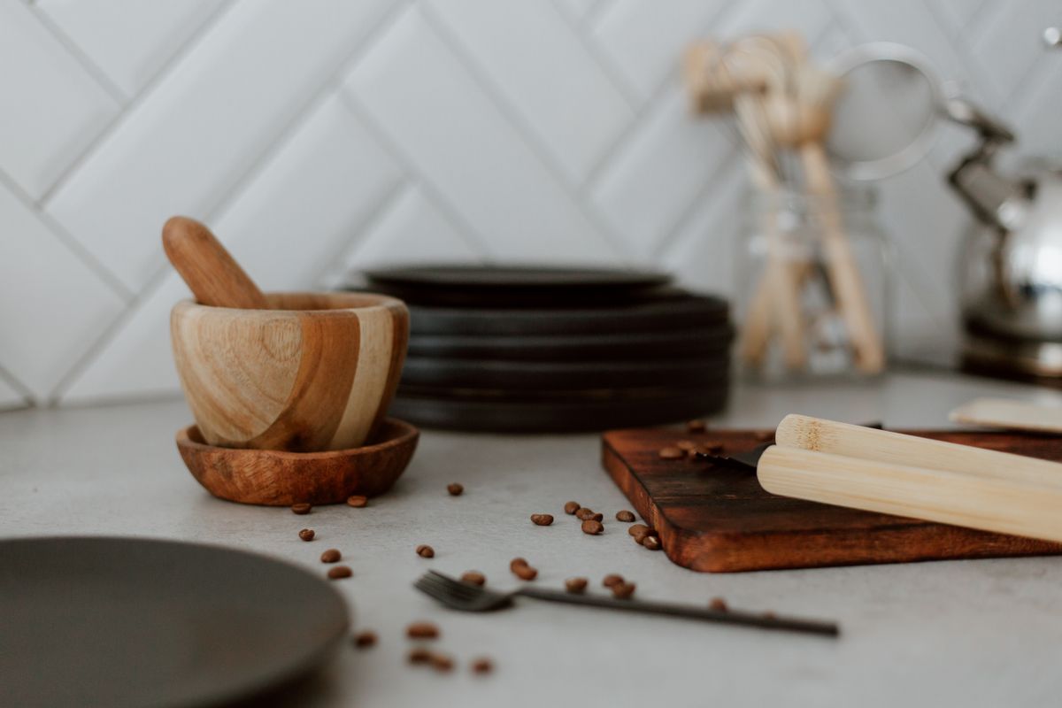 A cozy kitchen scene featuring a wooden mortar and pestle alongside coffee beans on a counter.