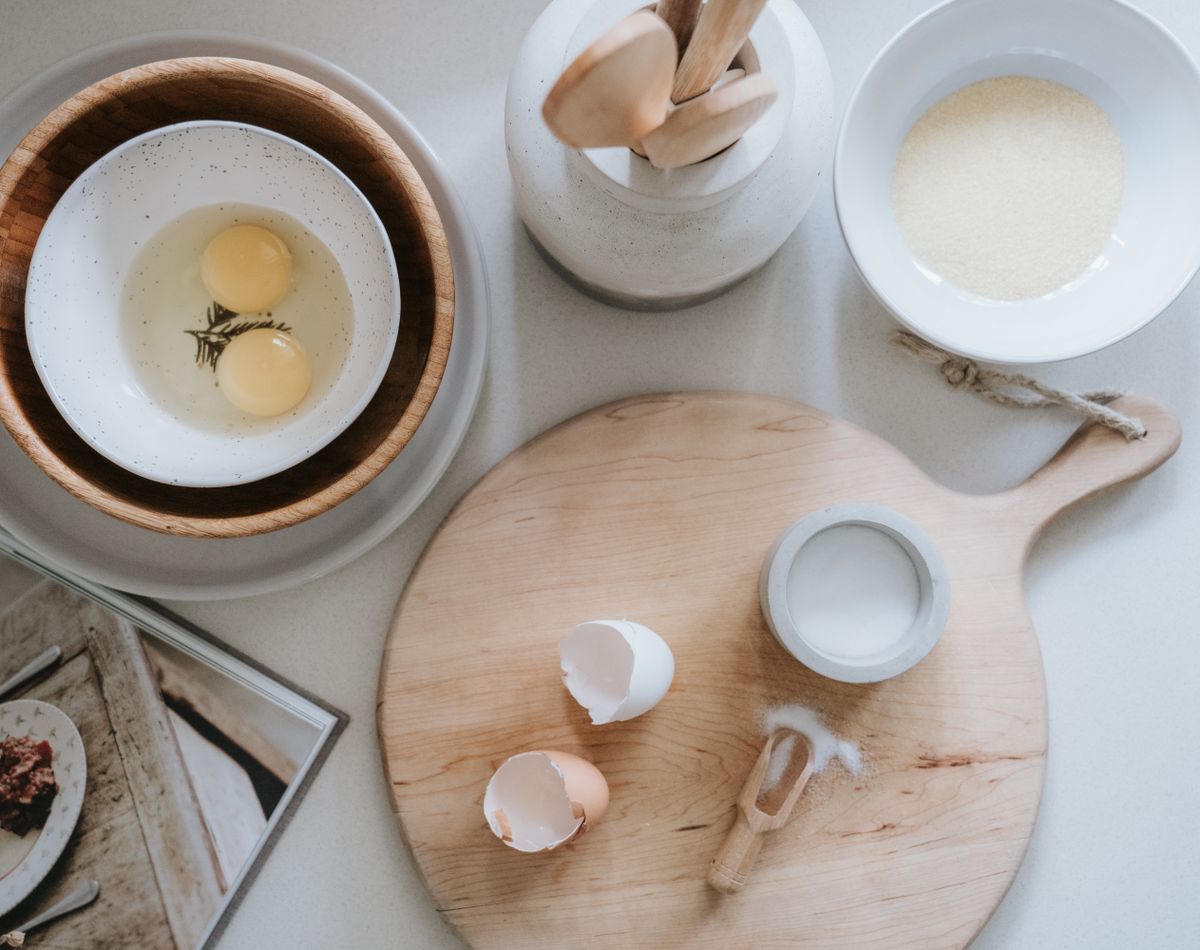 Elegant flat lay of kitchen ingredients and tools on a wooden surface.