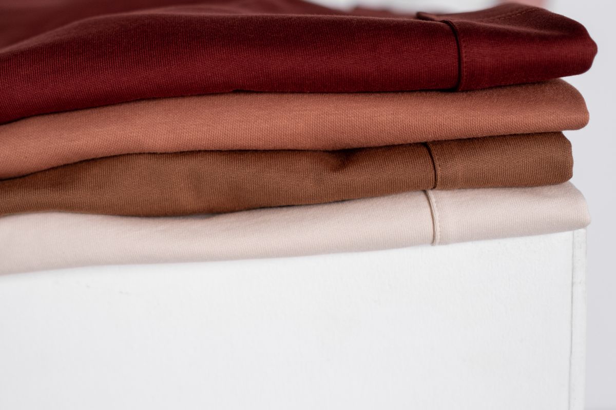 Close-up of neatly stacked neutral-tone clothes, showcasing fabric textures.