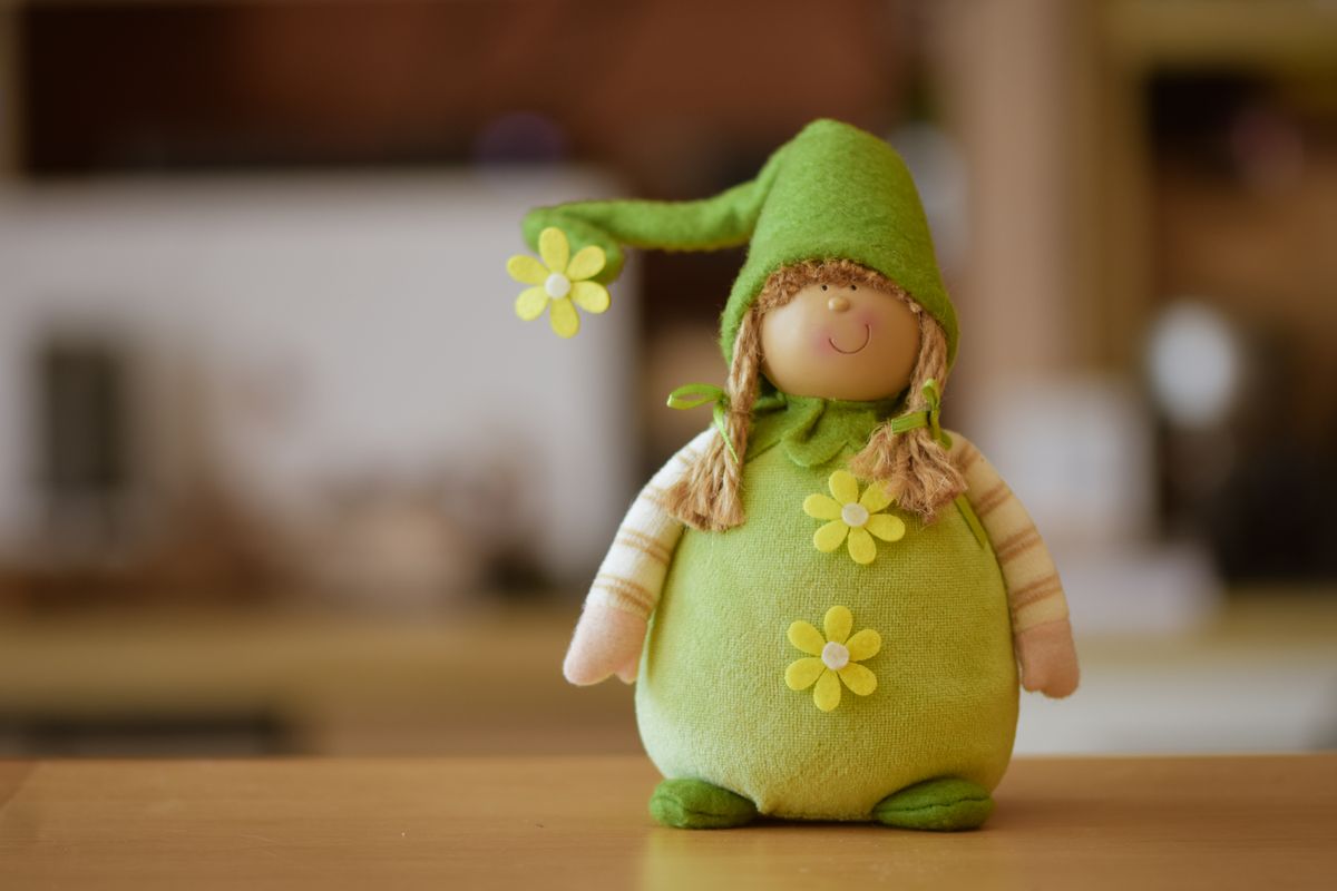 Adorable green plush toy with a flower accent, perfect for decoration or gifts.