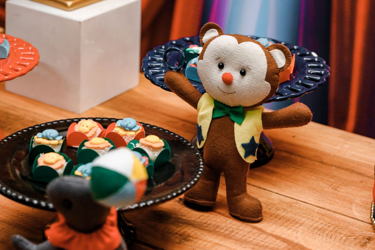 Whimsical party table with teddy bear and colorful desserts for a fun kids' celebration.