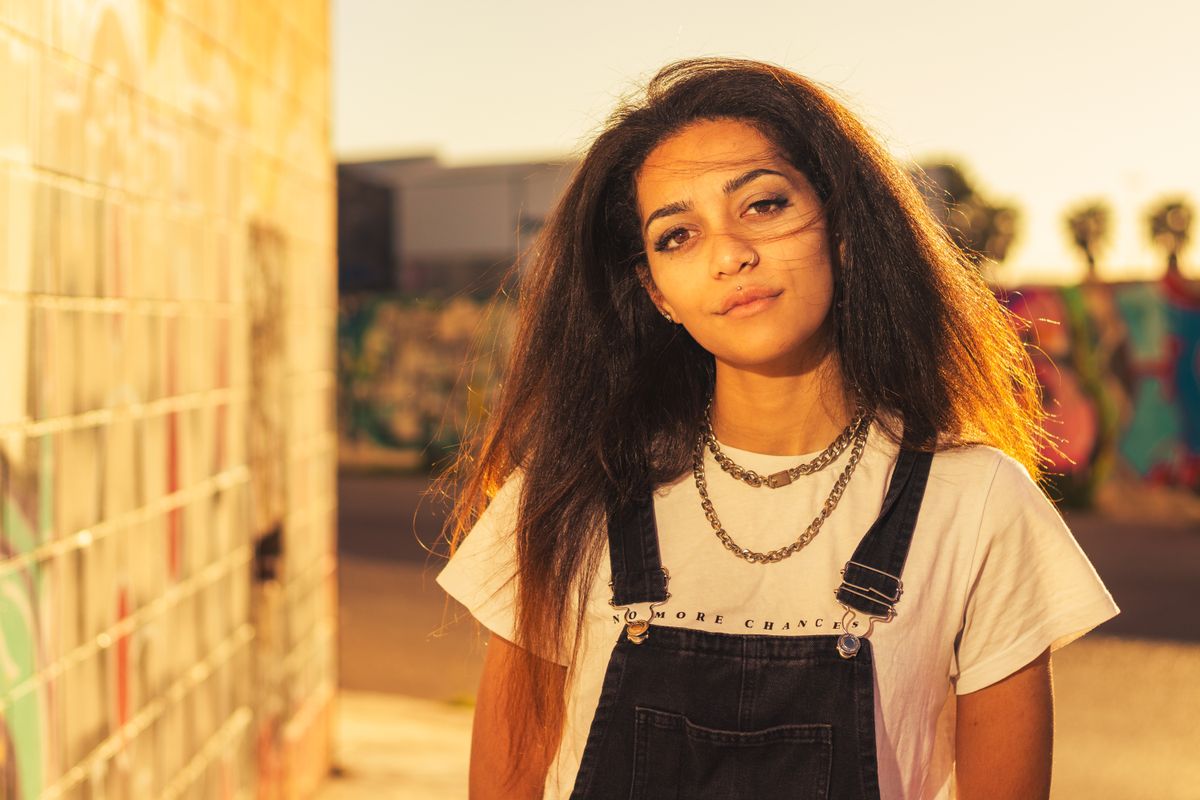 Confident young woman with a chain necklace in Valencia city street style.