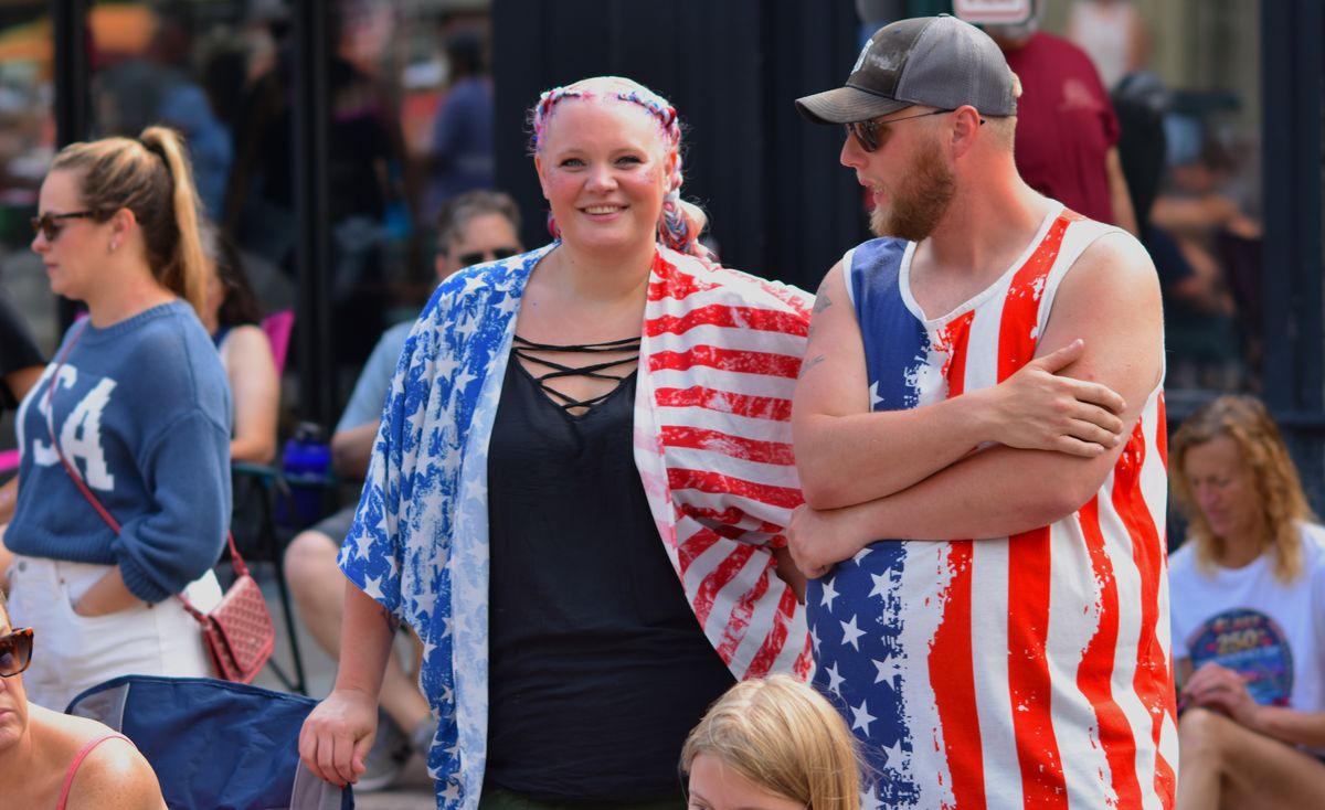 Group of adults enjoying a summer parade wearing American flag-themed clothing.