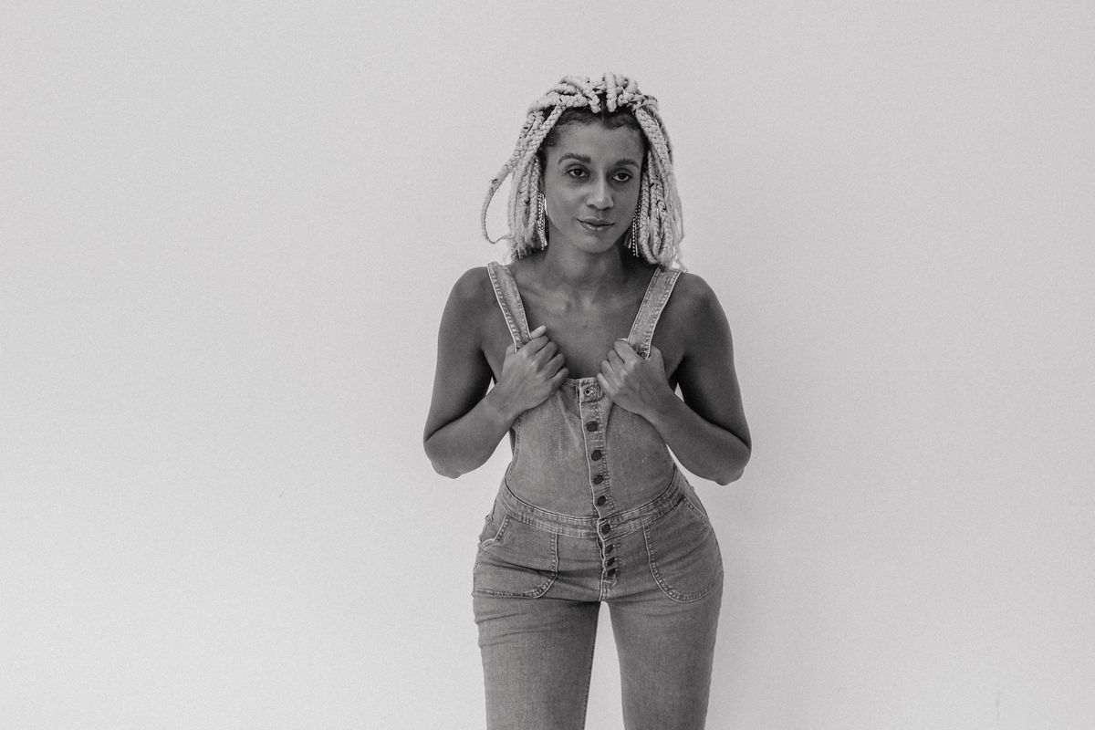 Stylish black and white portrait of a woman standing in overalls, São Paulo.