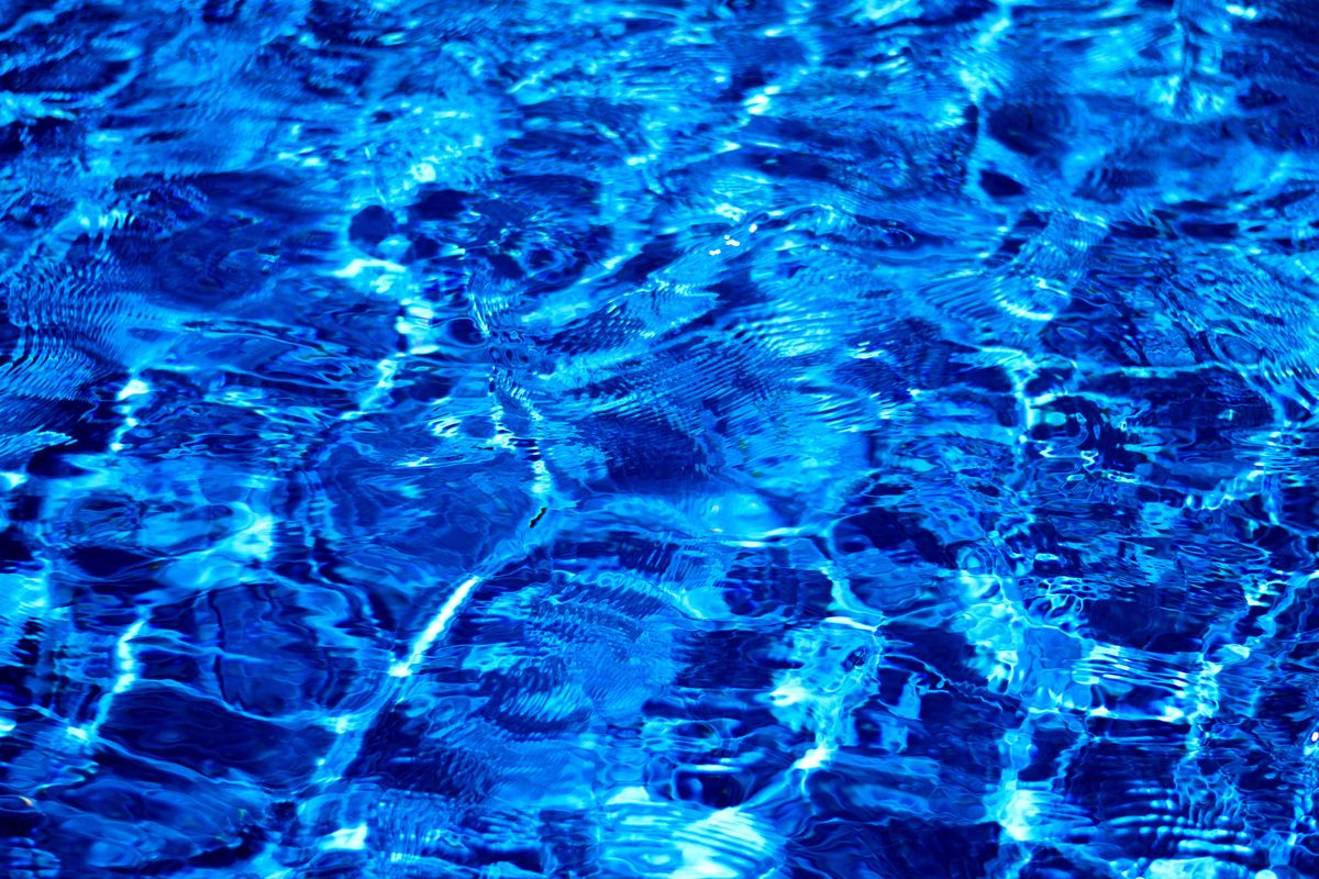 Dynamic and vibrant ripples on a blue water surface, showcasing light and texture.