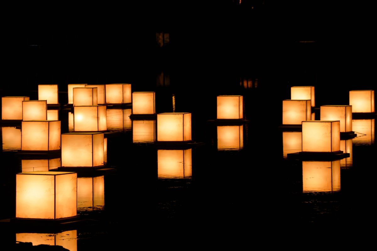 Serene floating lanterns create a warm glow on the water at night.