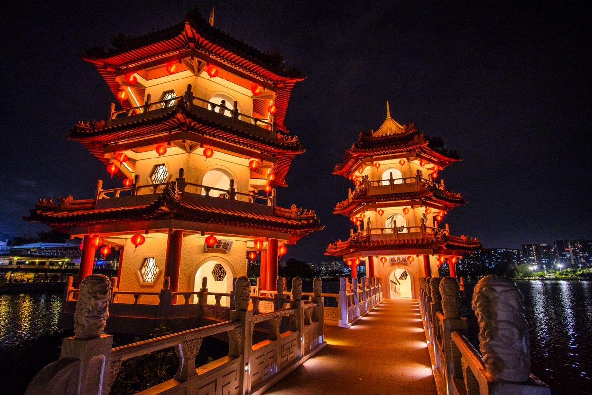 Stunning night view of a traditional Chinese pagoda at Jurong Lake Gardens, Singapore, beautifully lit with vibrant lights.