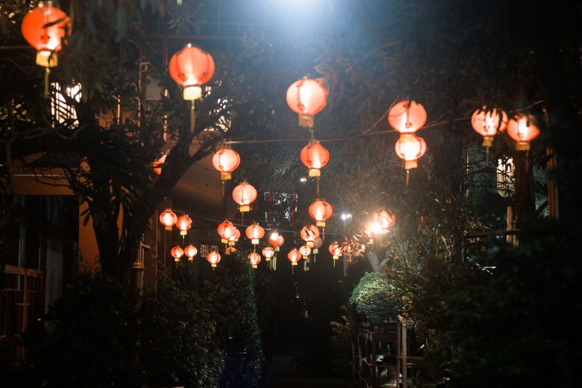Glowing red Chinese lanterns light up a garden path on a festive night in Indonesia.