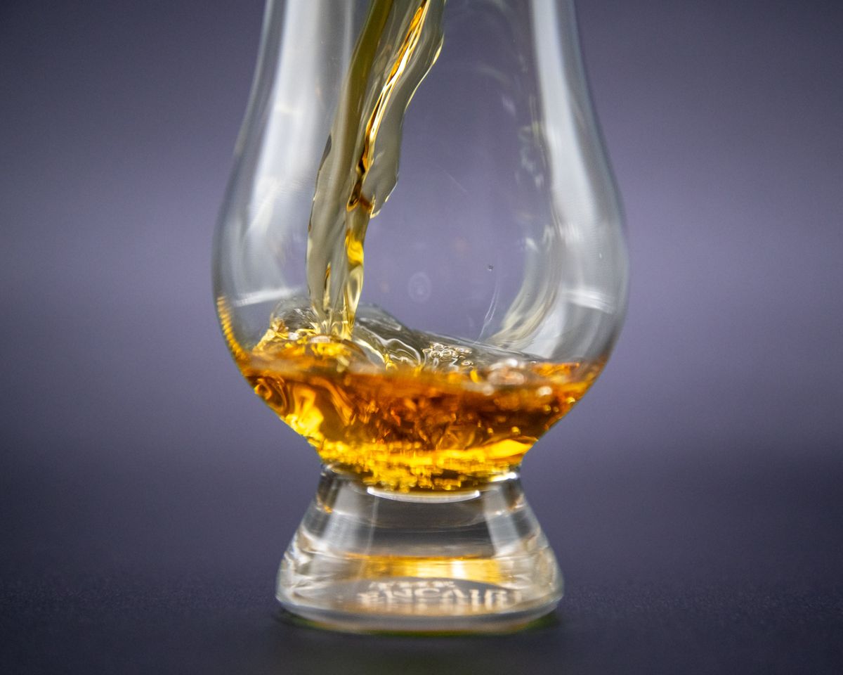 Close-up of golden whiskey being poured into an elegant glass.