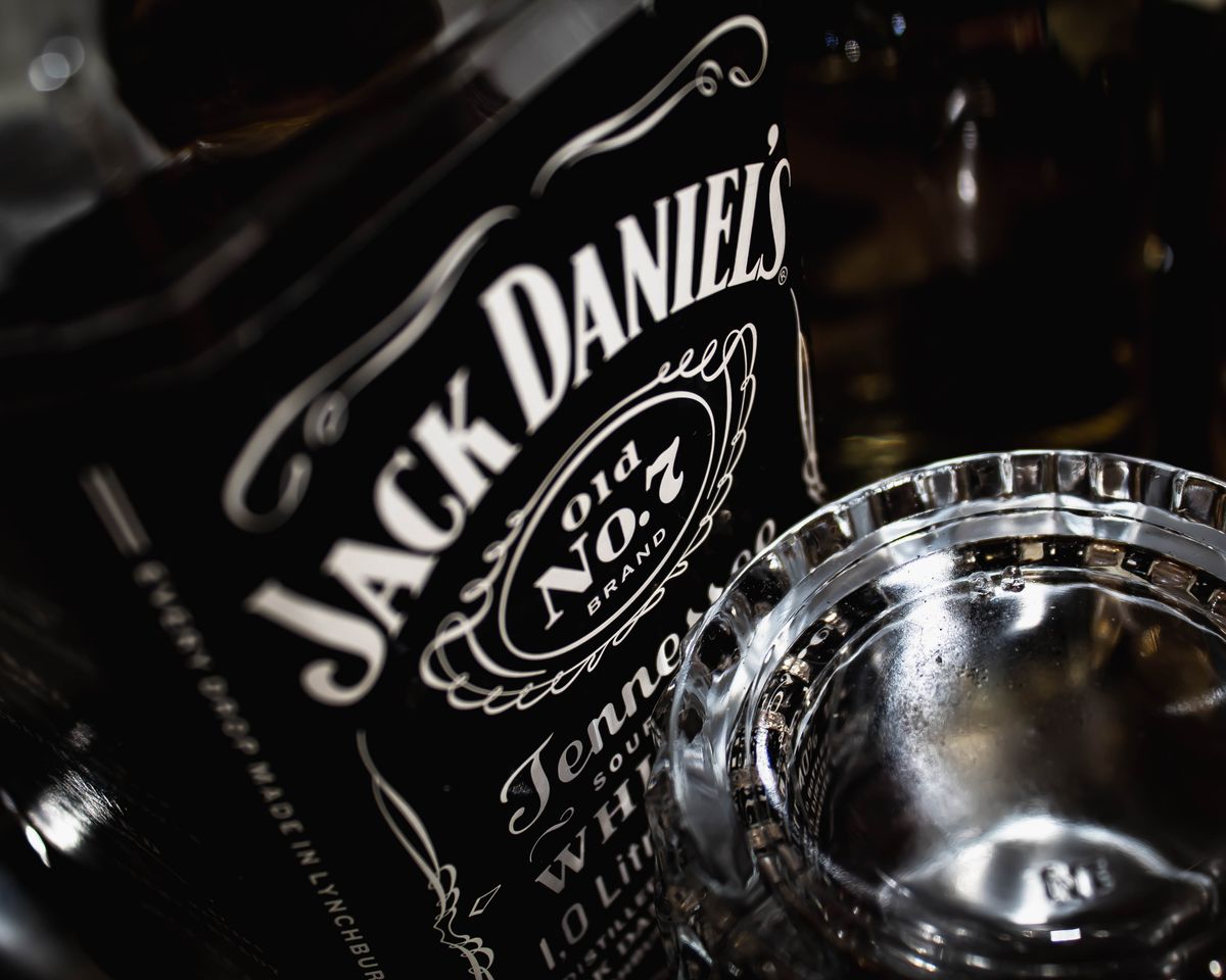 Detailed view of a Jack Daniel's whiskey bottle with glass, highlighting the brand's iconic label.