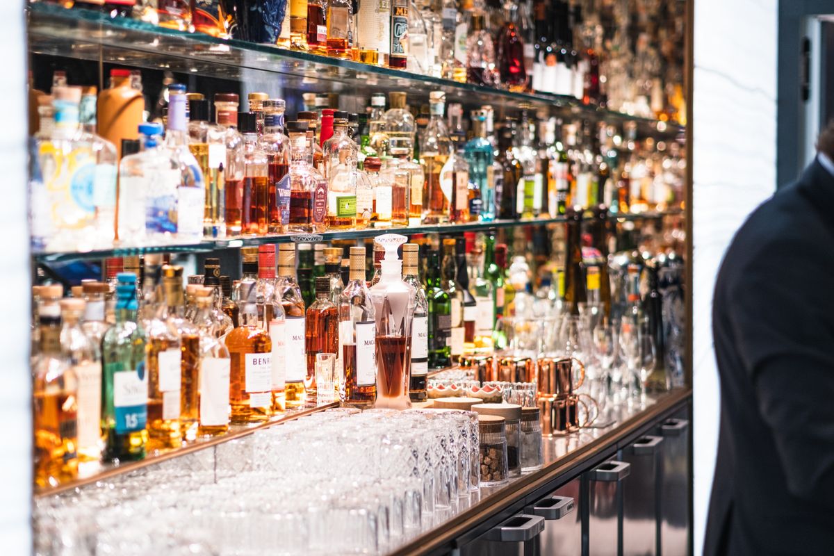 Colorful array of liquor bottles in a stylish Parisian bar setting.