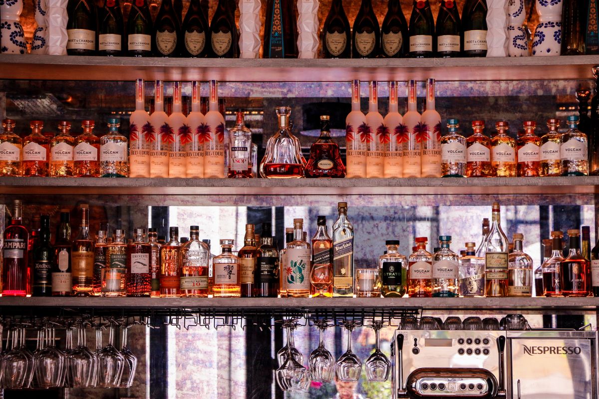 A well-stocked bar display featuring various bottles of liquor and glassware, perfect for nightlife scenes.