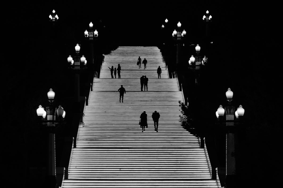 Dramatic night scene showcasing silhouettes on illuminated stairs in Baku, Azerbaijan.