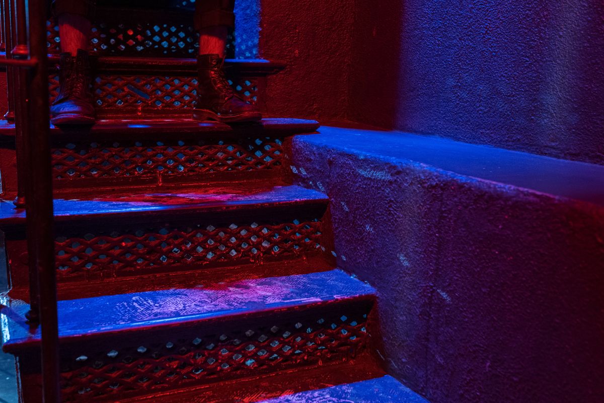 Colorful stairs at night with footwear, creating a moody nightlife vibe.