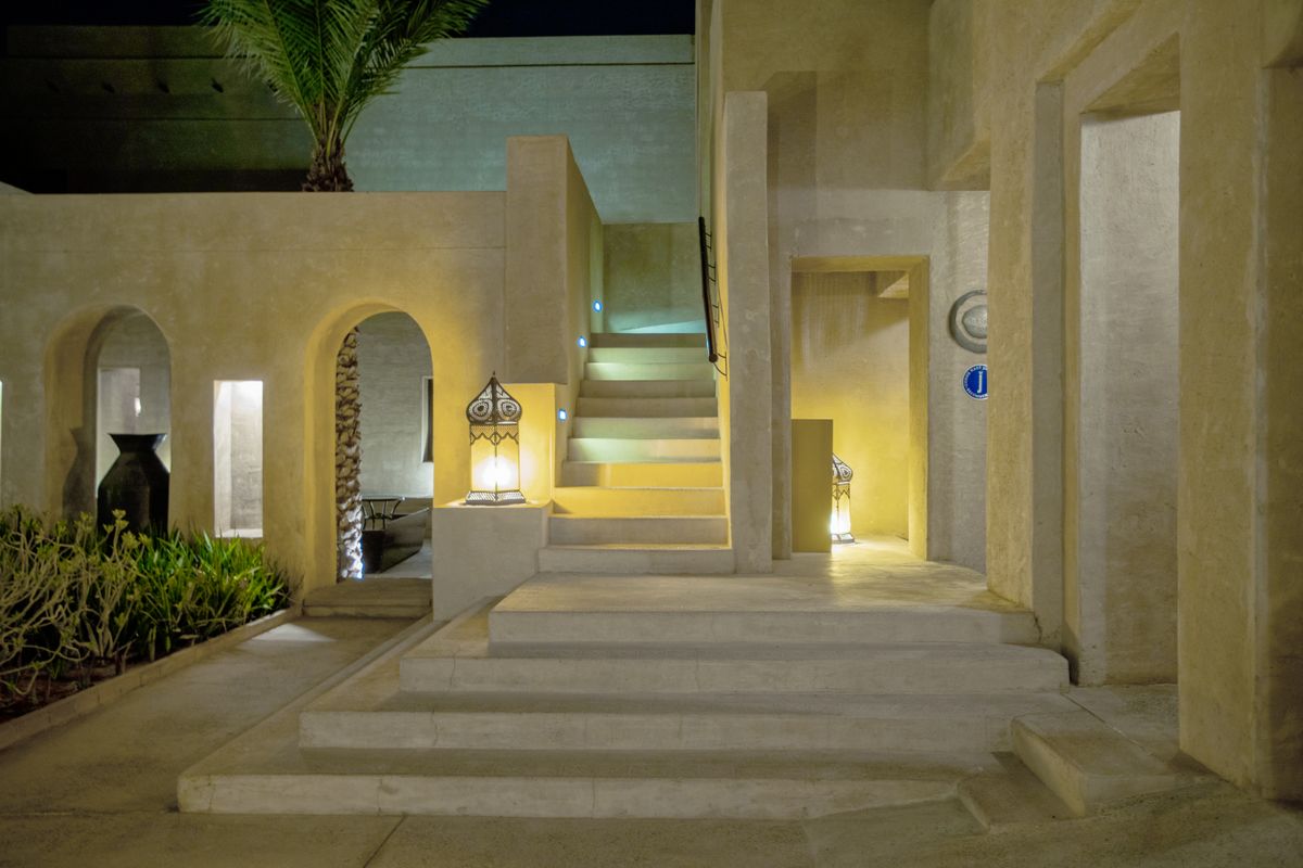 Modern Arabic-style architecture in Dubai featuring illuminated concrete structures and elegant stairs at night.