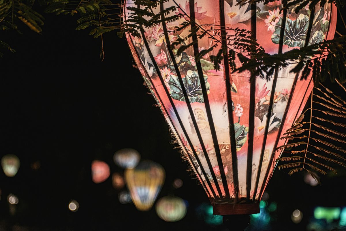 A vibrant floral-patterned lantern illuminates the night, creating a warm and festive atmosphere.