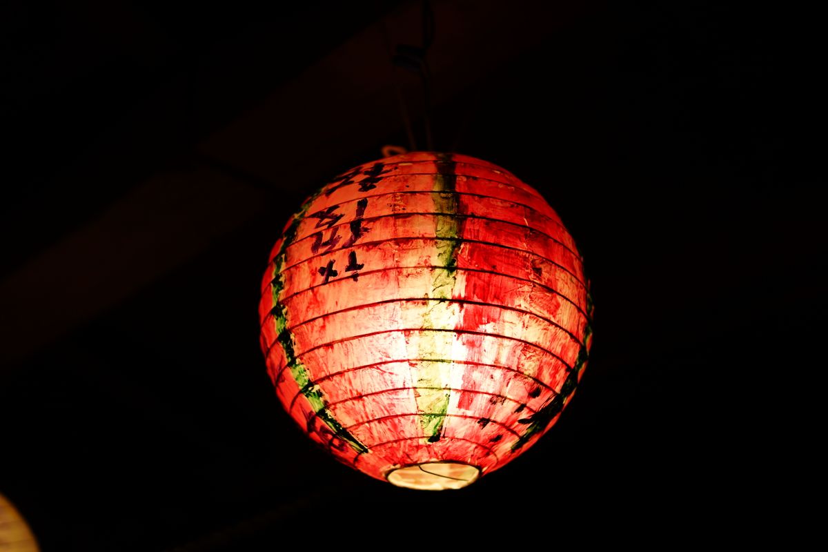 A glowing Japanese paper lantern illuminating the night with its vibrant colors and cultural charm.
