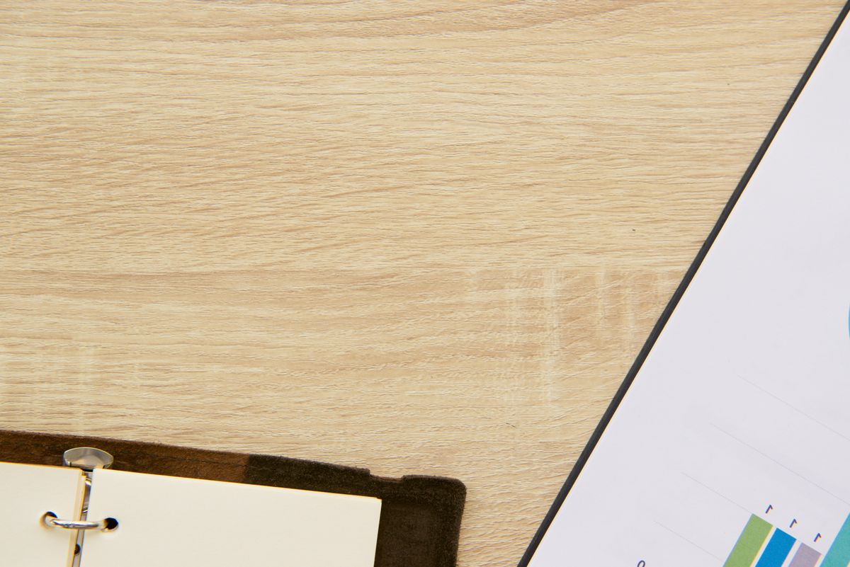 A minimalist desk setup featuring a notebook and a chart for planning or analysis.
