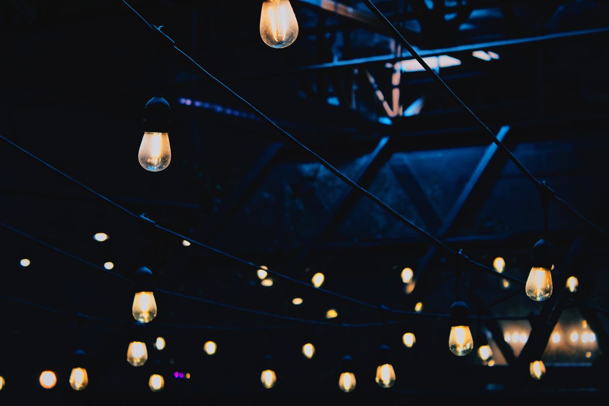 Illuminated string lights create a moody ambiance in a dark industrial interior, perfect for night settings.