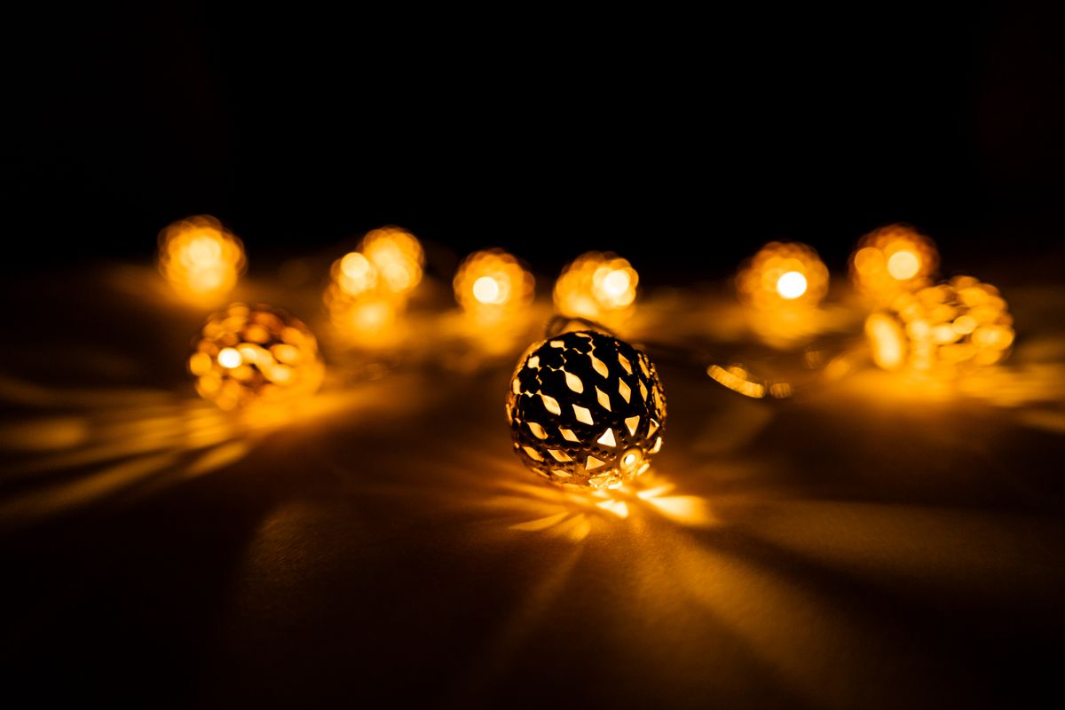 Close-up view of illuminated decorative string lights casting warm glow in the dark.