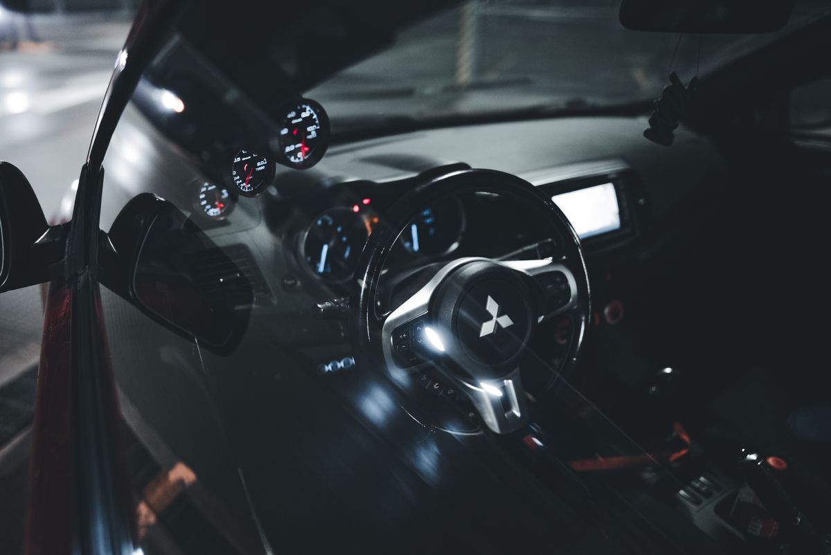 A sleek Mitsubishi car interior showcasing an illuminated dashboard and steering wheel, captured at night.