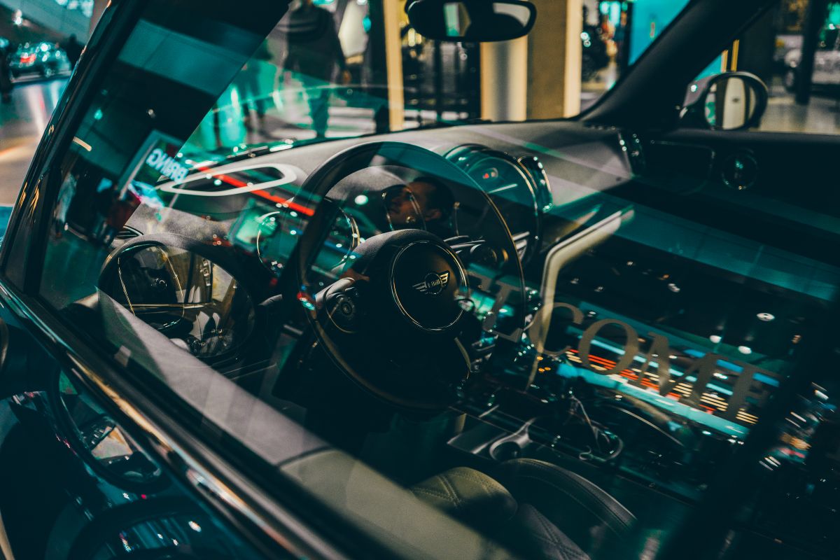 Elegant car interior showcasing luxury design with reflections of Munich city lights at night.