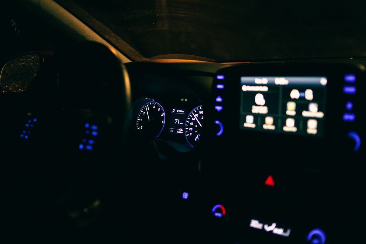 Dashboard of modern car with glowing indicators and display parked on street at night