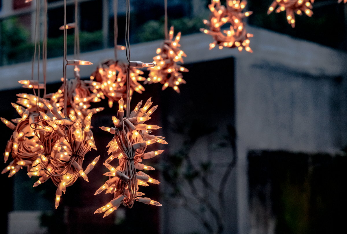 Warm glowing outdoor string lights hanging against a building backdrop in Dhaka, Bangladesh.