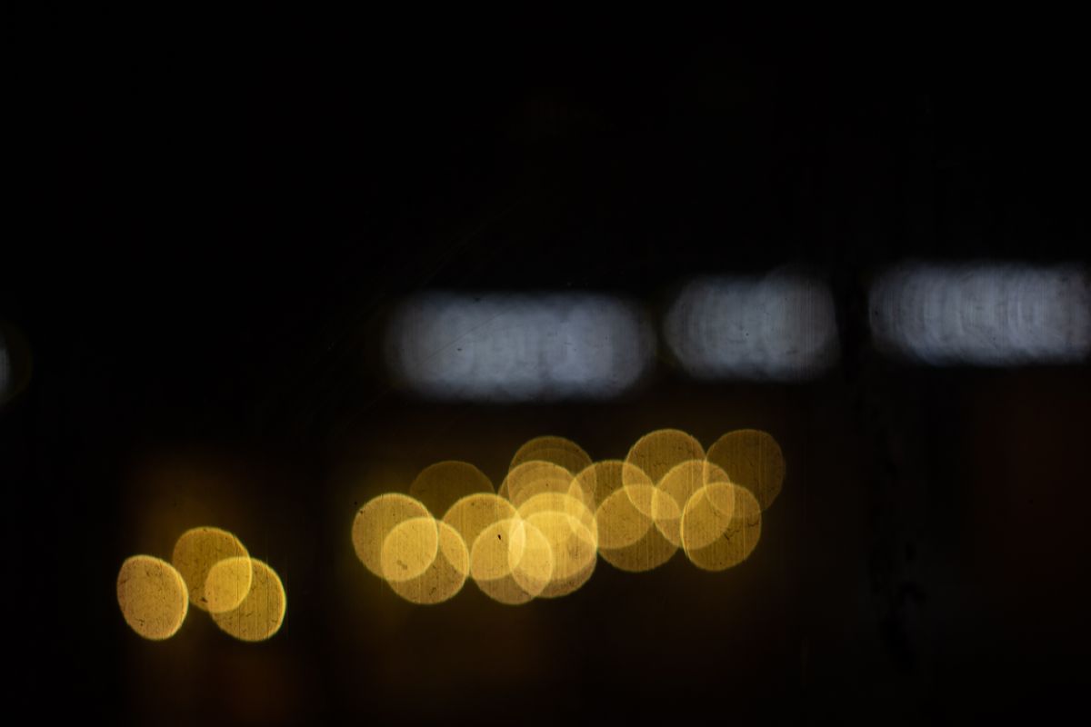 Blurred golden bokeh lights against a dark background, creating an abstract night scene.
