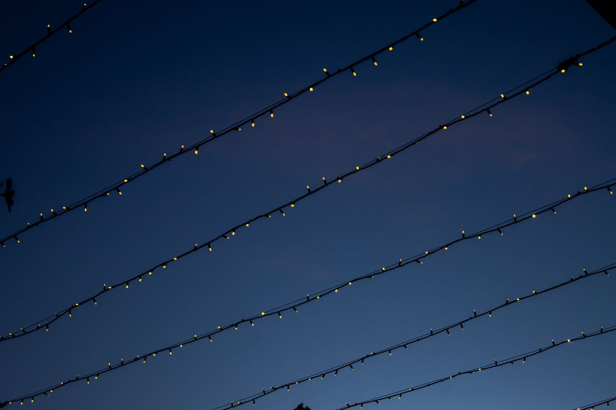 Captivating view of outdoor string lights glowing warmly against a serene twilight sky.