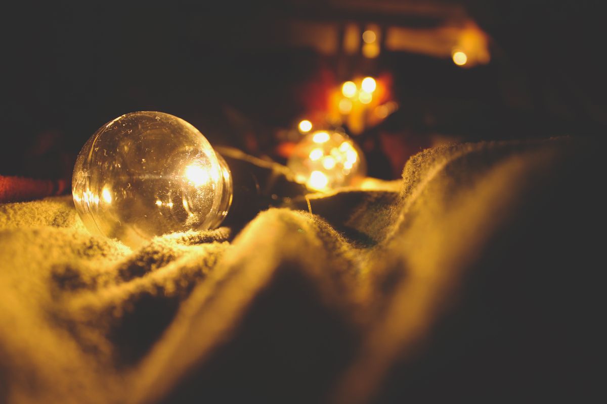 Cozy scene with illuminated light bulbs emitting a warm glow on a soft blanket.