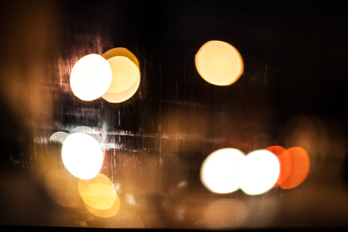 Colorful bokeh lights forming abstract patterns at night, capturing a warm, vibrant urban atmosphere.