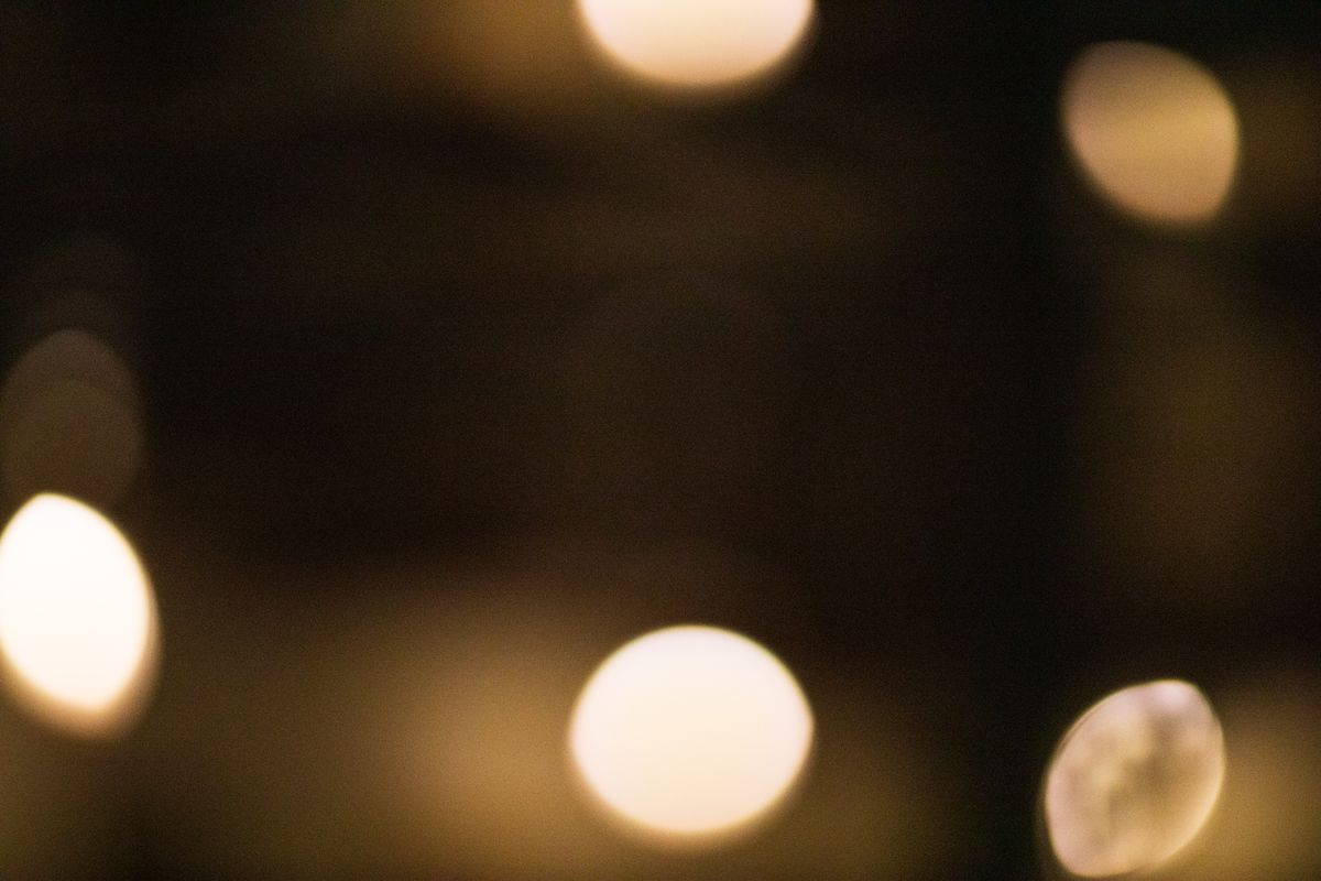 Blurred abstract bokeh backdrop with glowing white and beige oval shaped lights at night