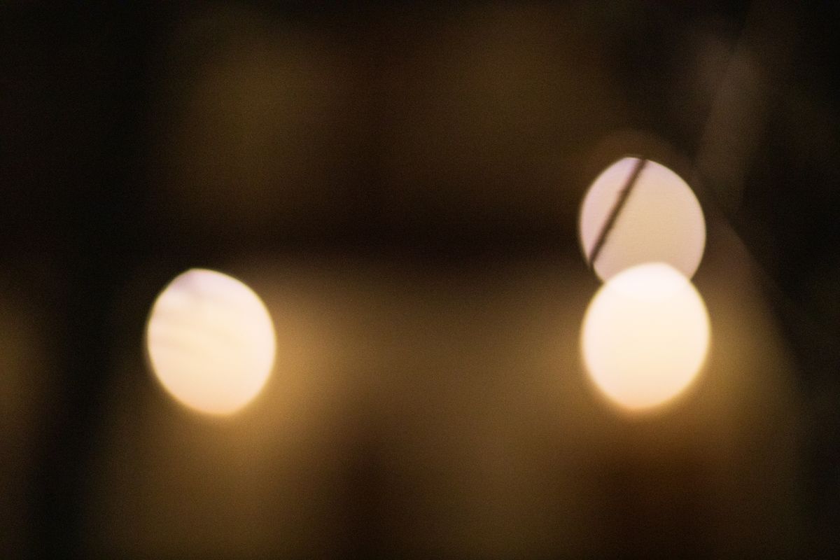 Defocused abstract bokeh background with bright oval shaped beige lights with inclined line in evening