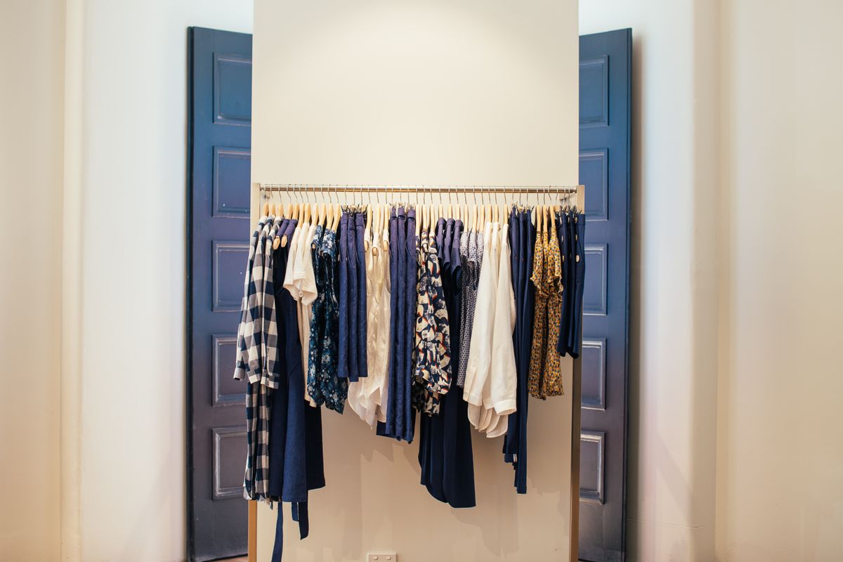Neatly organized clothes on hangers in a stylish wardrobe display.