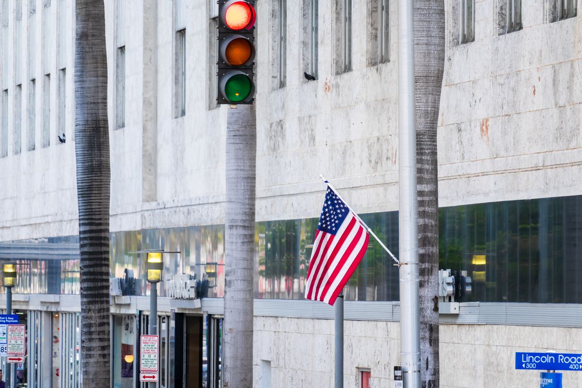 American flag flutters near traffic light on Lincoln Road in Miami Beach.