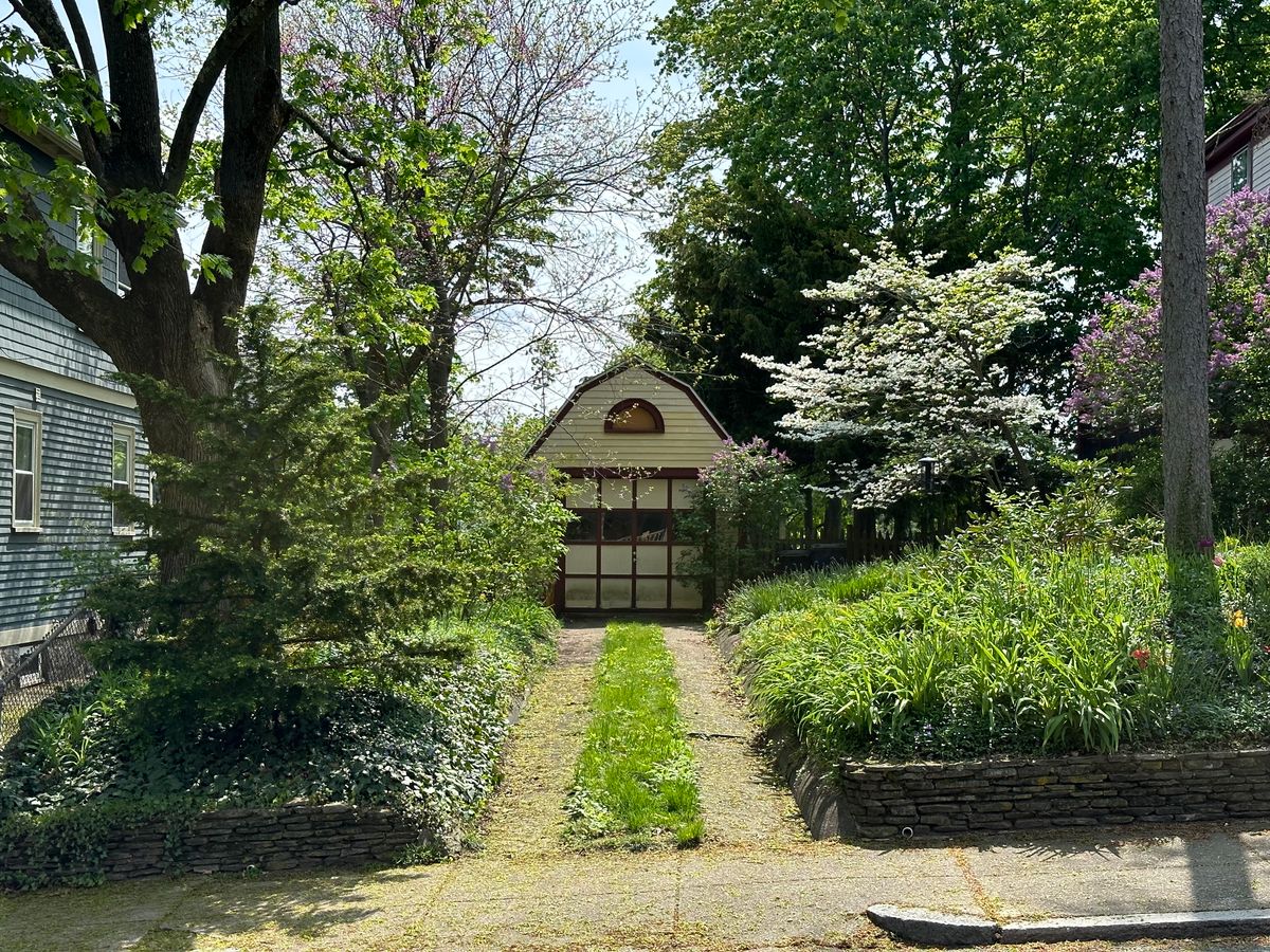 Beautiful garden path leading to a quaint shed surrounded by vibrant greenery.