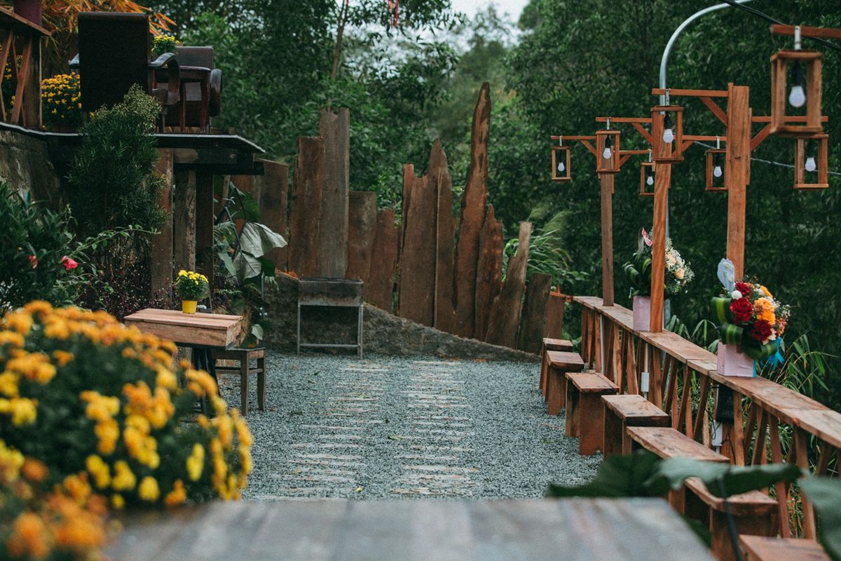 Charming outdoor garden scene featuring a rustic path with wooden benches and vibrant flowers.
