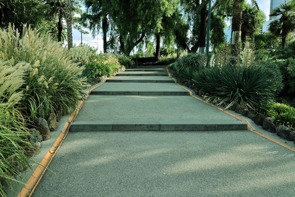 Peaceful garden pathway surrounded by vibrant plants and trees, perfect for relaxation.