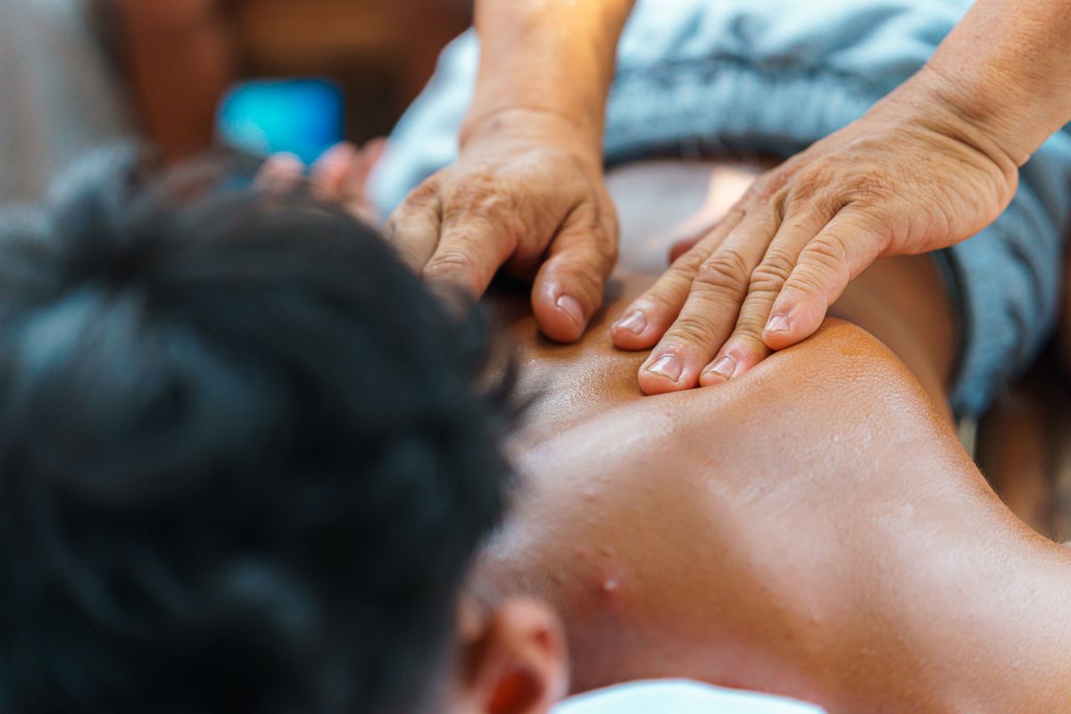 Close-up of hands performing a therapeutic back massage, promoting relaxation and wellness.