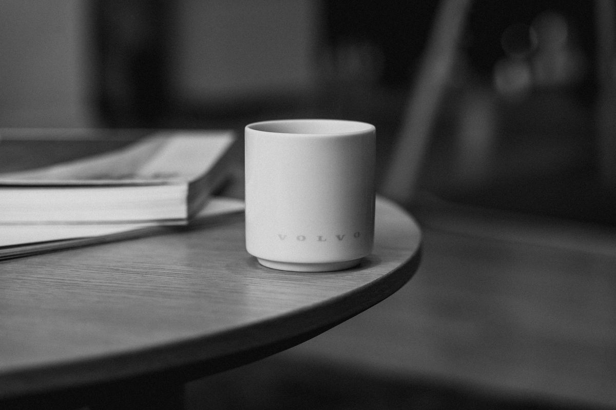 A monochrome image of a cup on a wooden table, creating a minimalist and modern scene.